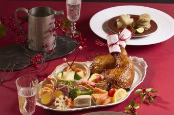 ローストチキンと彩り前菜を盛り合わせたクリスマスの食卓イメージ。赤いテーブルクロスと季節の飾りを添えた華やかなパーティー料理。